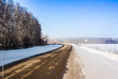 Beautiful winter landscape with asphalt road, forest and blue sky. Frozen wintry day and path drive. A lot of snow.