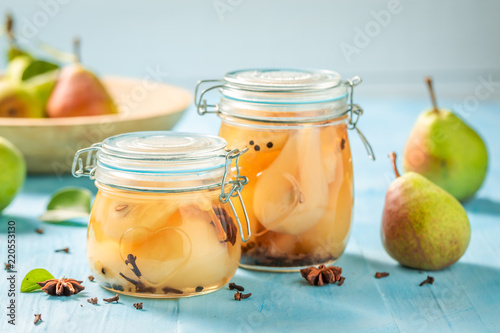 Natural and juicy pickled pears on blue table