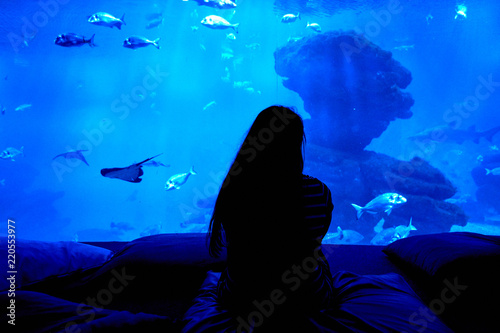 Woman Silhouette with aquarium tank background full of fish