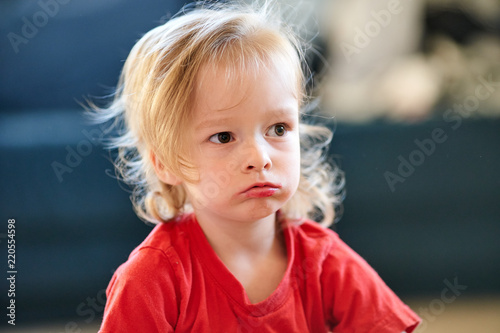 Fotografie beautifull girl child with red t-shirt is siiting angry sad