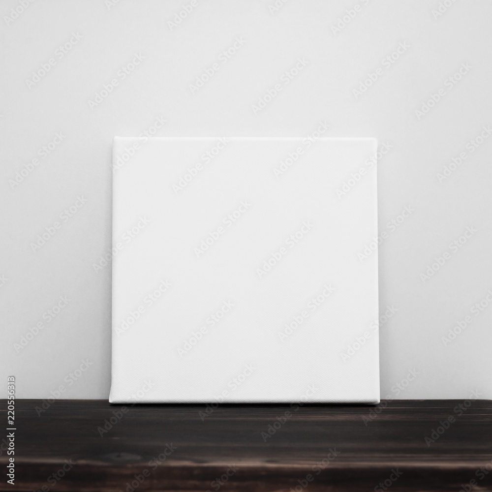White square canvas. Gray wall and wooden floor background. Poster template. White square canvas. Gray wall and wooden floor background. Poster template.