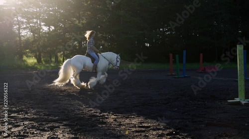 Young woman riding horse during a summer sunset. Slow Motion