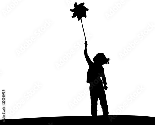 Little girl playing with wind toy or pinwheel. Happy girl silhouette