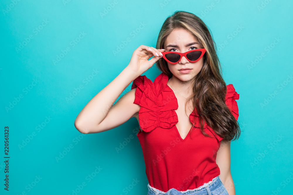 Young woman in sunglasses in summer dress isolated on blue background Young woman in sunglasses in summer dress isolated on blue background