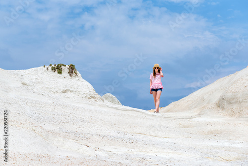 A beautiful young woman standing on white rock. Beach of Sarakiniko. Milos  Greece