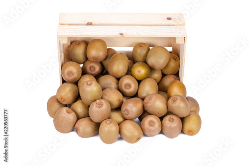 Wooden box with ripe kiwi fruits in front of it isolated on white background