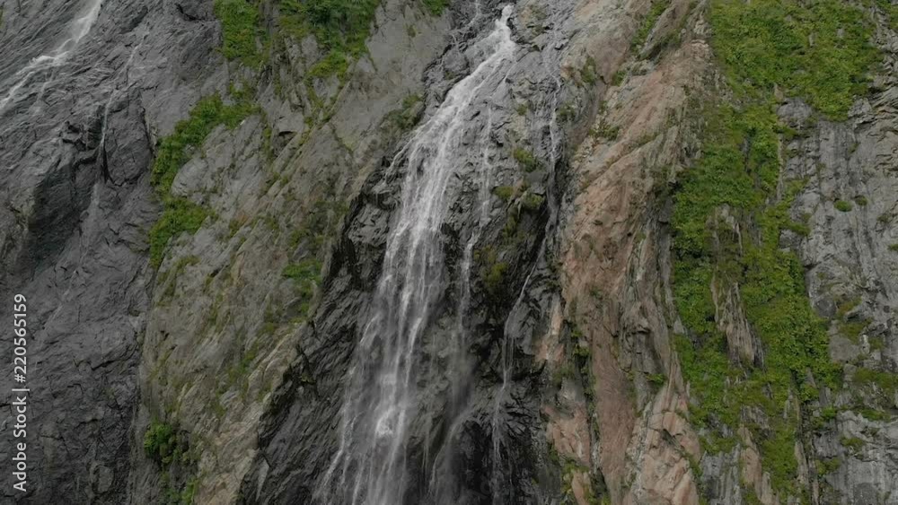 Tracking and top shot Air shot from a stream of water splashing waterfall on a rock wall in the Caucasus Mountains. Around the jet of the waterfall Tracking and top shot Air shot from a stream of water splashing waterfall on a rock wall in the Caucasus Mountains. Around the jet of the waterfall