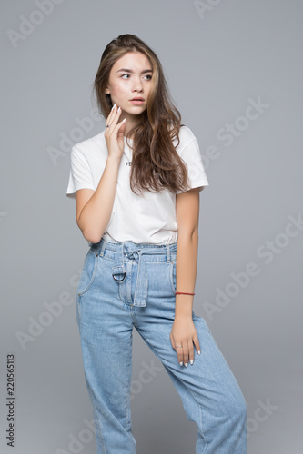 Beautiful young woman in white shirt on grey background