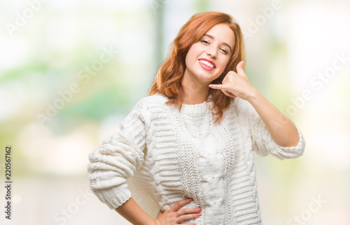 Young beautiful woman over isolated background wearing winter sweater smiling doing phone gesture with hand and fingers like talking on the telephone. Communicating concepts.
