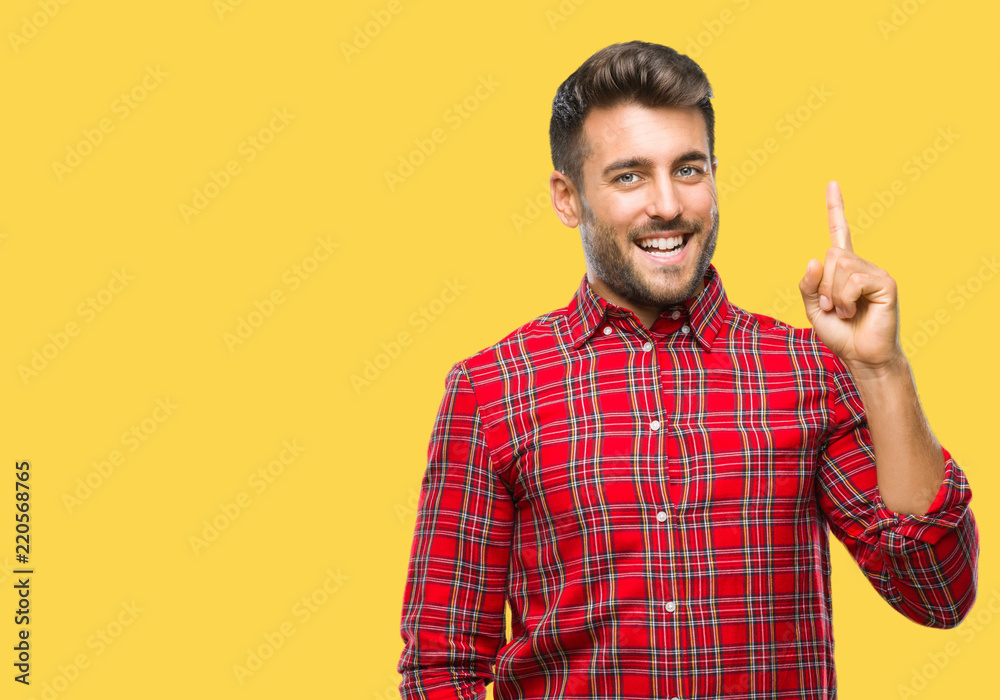 Young handsome man over isolated background pointing finger up with successful idea. Exited and happy. Number one.