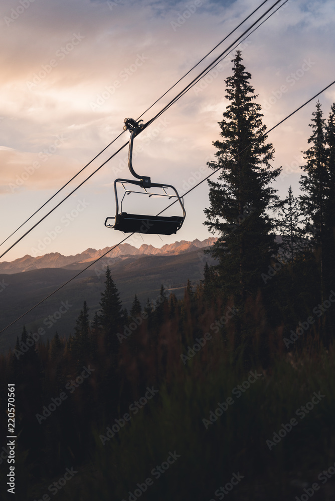 A silhouette of a chair lift in Vail, Colorado with mountains in the background. 