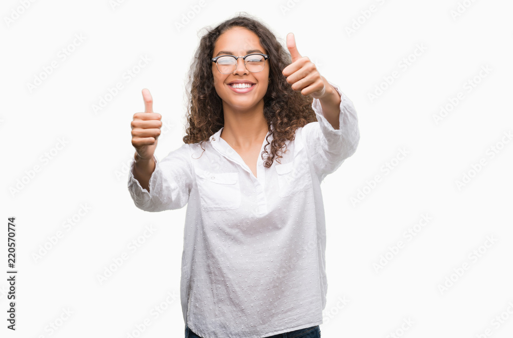Beautiful young hispanic woman approving doing positive gesture with hand, thumbs up smiling and happy for success. Looking at the camera, winner gesture. Beautiful young hispanic woman approving doing positive gesture with hand, thumbs up smiling and happy for success. Looking at the camera, winner gesture.