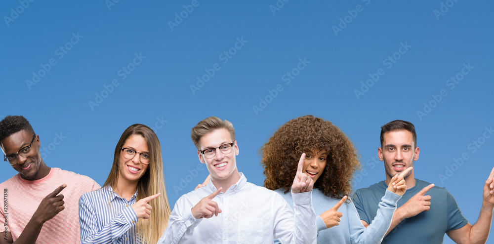 Composition of group of friends over blue blackground smiling and looking at the camera pointing with two hands and fingers to the side.