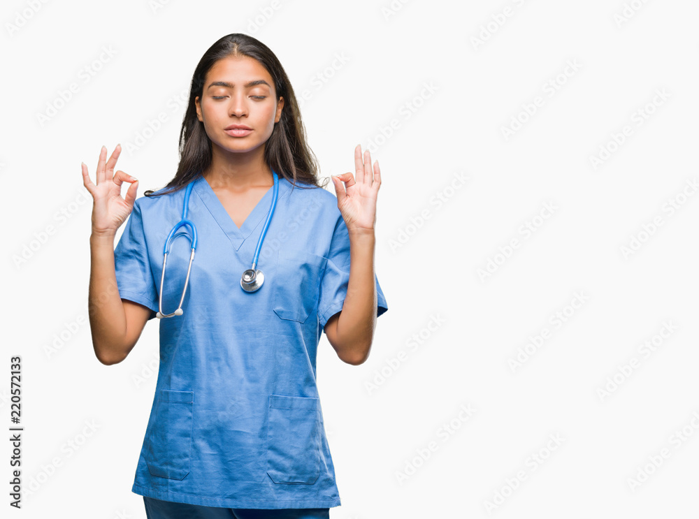 Young arab doctor surgeon woman over isolated background relax and smiling with eyes closed doing meditation gesture with fingers. Yoga concept. Young arab doctor surgeon woman over isolated background relax and smiling with eyes closed doing meditation gesture with fingers. Yoga concept.