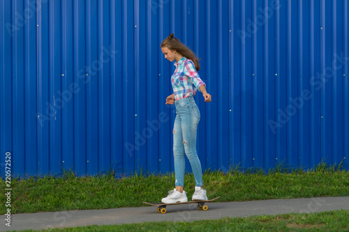 Slender young woman in jeans out skateboarding