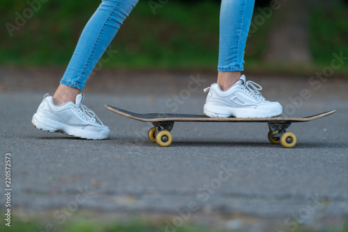 Obraz na płótnie Young woman pushing herself on a skateboard w salonie