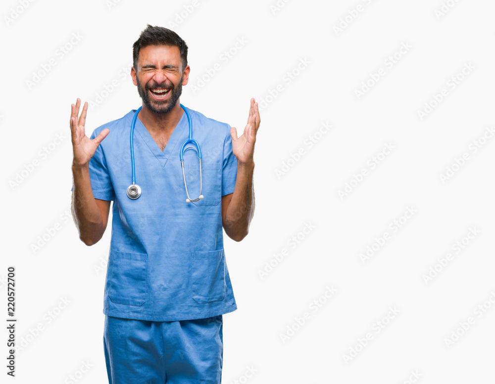 Adult hispanic doctor or surgeon man over isolated background celebrating mad and crazy for success with arms raised and closed eyes screaming excited. Winner concept Adult hispanic doctor or surgeon man over isolated background celebrating mad and crazy for success with arms raised and closed eyes screaming excited. Winner concept