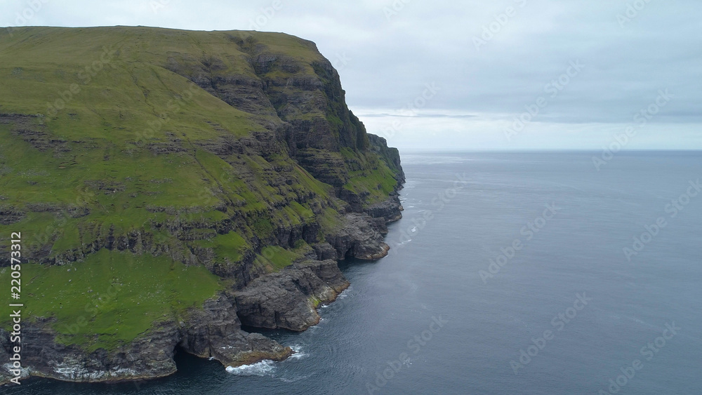 AERIAL: Flying towards a breathtaking cliff overlooking the endless cold ocean.