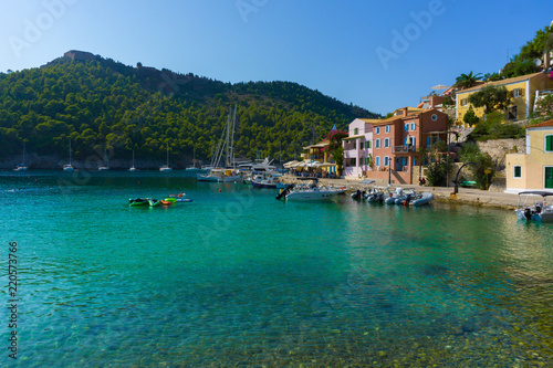 View of a bay with turquoise waters and traditional colorful houses in Assos village, Kefalonia, Greece