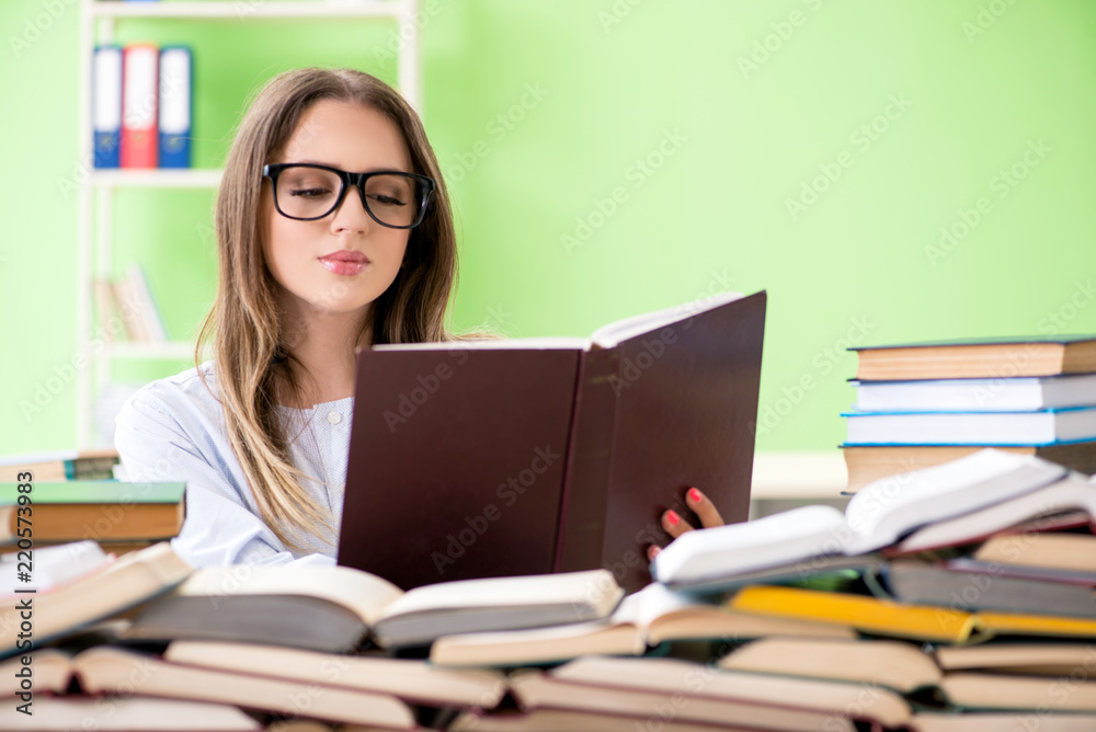 Young female student preparing for exams with many books Young female student preparing for exams with many books