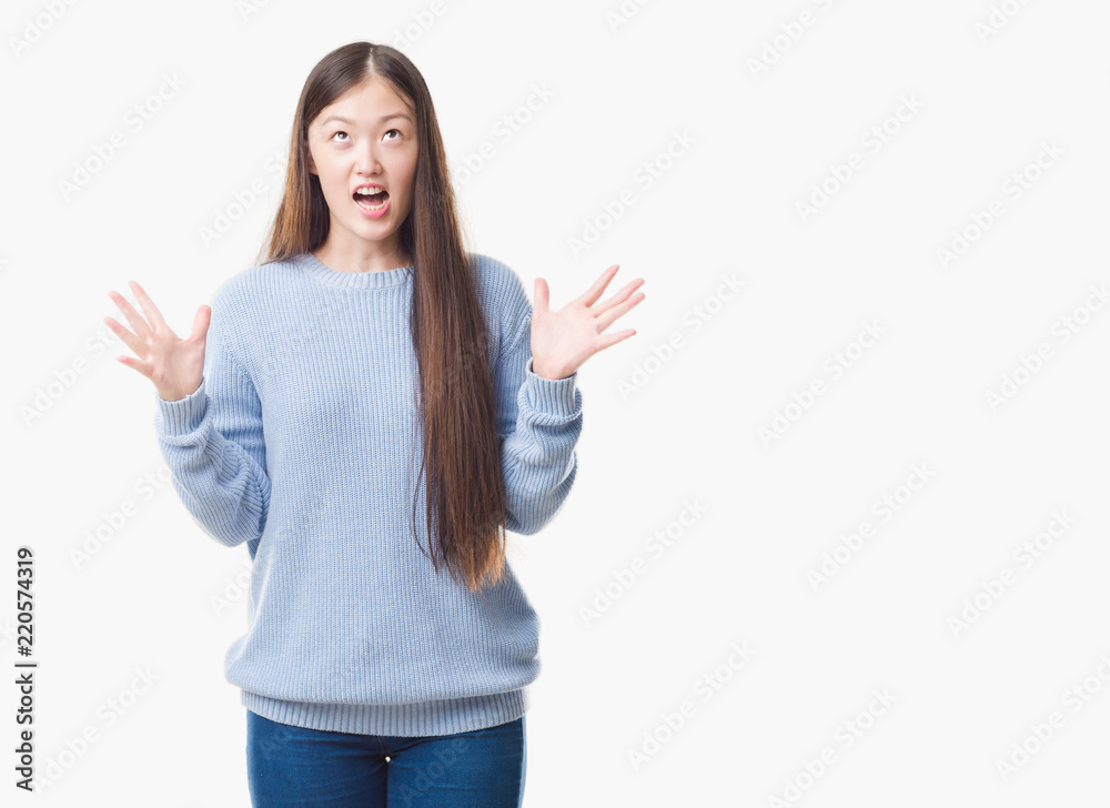 Young Chinese woman over isolated background crazy and mad shouting and yelling with aggressive expression and arms raised. Frustration concept. Young Chinese woman over isolated background crazy and mad shouting and yelling with aggressive expression and arms raised. Frustration concept.