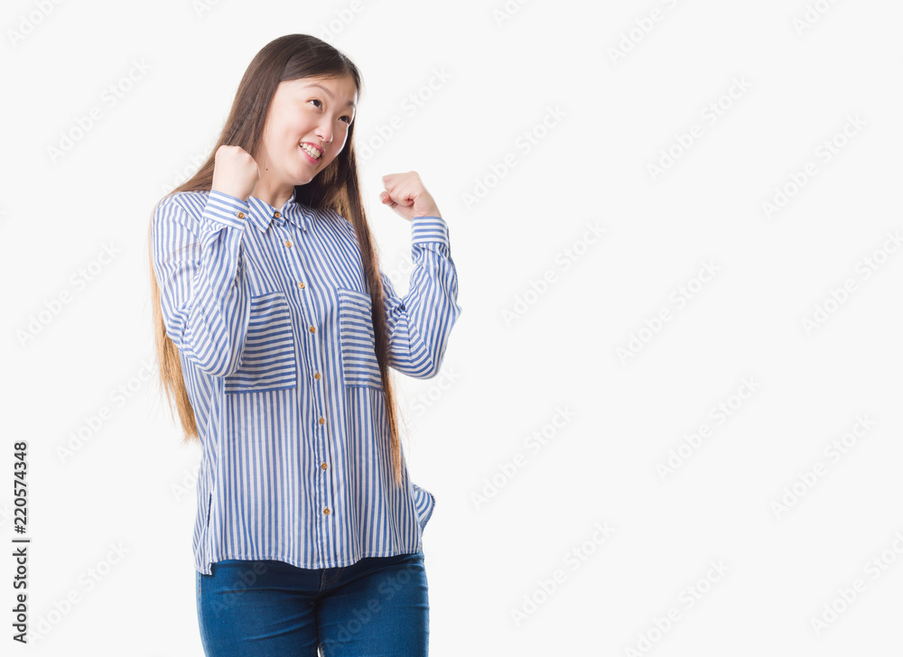 Young Chinese woman over isolated background very happy and excited doing winner gesture with arms raised, smiling and screaming for success. Celebration concept. Young Chinese woman over isolated background very happy and excited doing winner gesture with arms raised, smiling and screaming for success. Celebration concept.