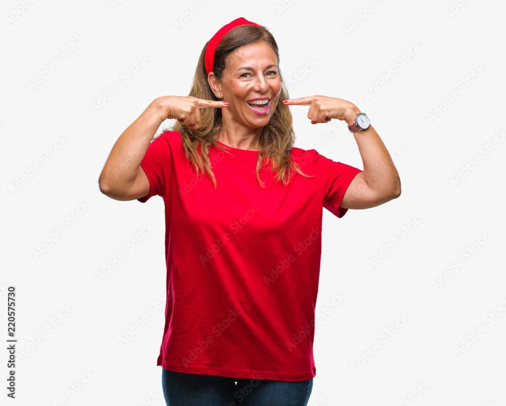 Middle age senior hispanic woman over isolated background smiling confident showing and pointing with fingers teeth and mouth. Health concept. Middle age senior hispanic woman over isolated background smiling confident showing and pointing with fingers teeth and mouth. Health concept.