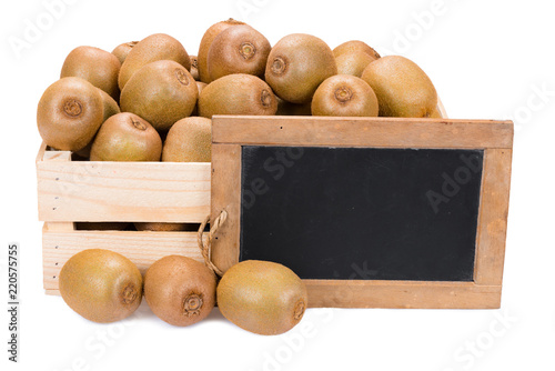 Wooden box filled with many ripe kiwi fruits and a old blank slate blackboard isolated on white background
