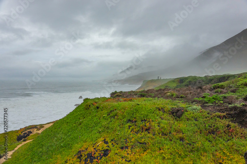 Beautiful ocean, green tropical hiills and cliffs mountains covered by deep fog. photo