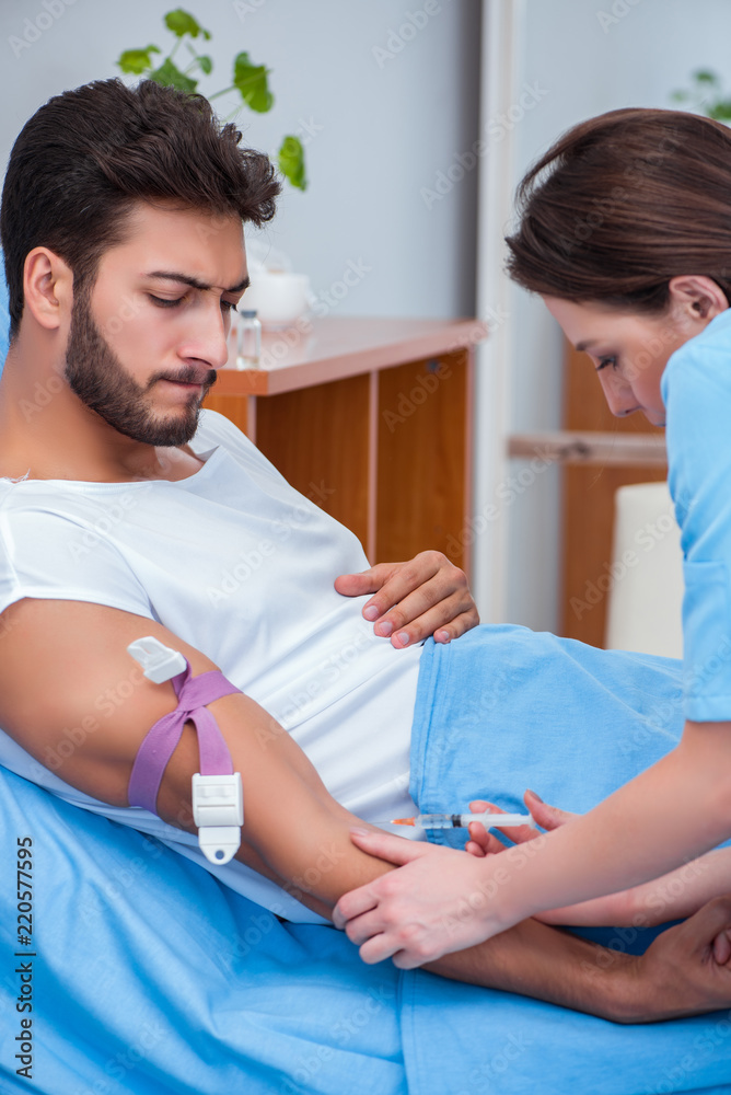 Woman doctor examining male patient in hospital Woman doctor examining male patient in hospital