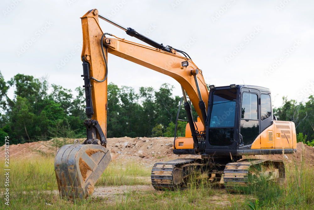 Yellow construction transport excavator digging earth outdoors Yellow construction transport excavator digging earth outdoors