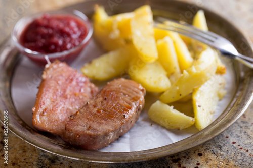 Backed tuna fish fillet with potatos on plate