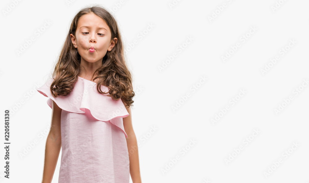 Brunette hispanic girl wearing pink dress making fish face with lips, crazy and comical gesture. Funny expression. Brunette hispanic girl wearing pink dress making fish face with lips, crazy and comical gesture. Funny expression.