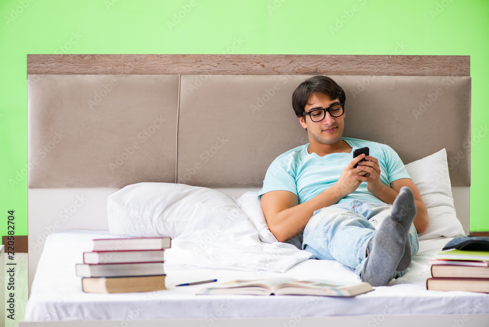 Student preparing for exams at home in bedroom lying on the bed Student preparing for exams at home in bedroom lying on the bed