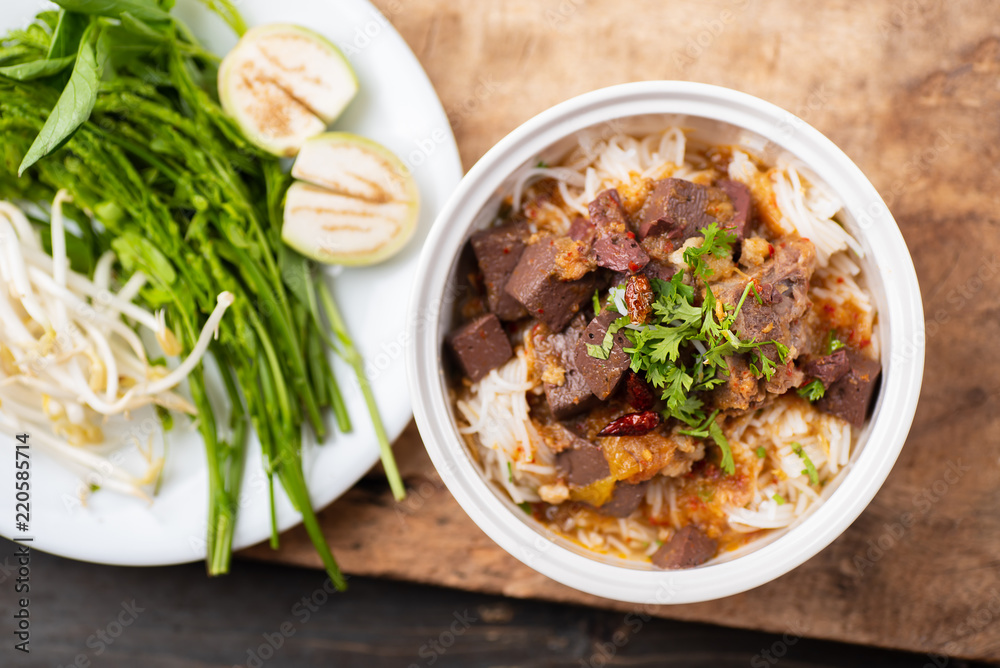 Northern Thai food (Kanom Jeen Nam Ngeaw) with vegetables on wooden background,spicy rice noodles soup Northern Thai food (Kanom Jeen Nam Ngeaw) with vegetables on wooden background,spicy rice noodles soup