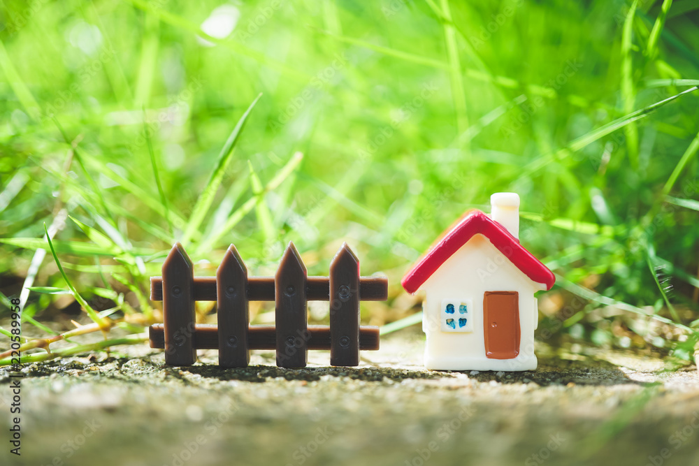 Miniature house on green nature background using as family and property  concept Stock Photo | Adobe Stock