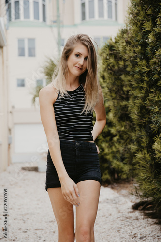 Cute Attractive Blonde Young Woman in Stripes Smiling and Posing for Camera Downtown 