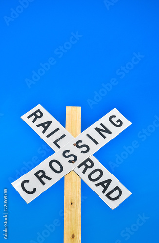 Railroad crossing sign against a blue sky