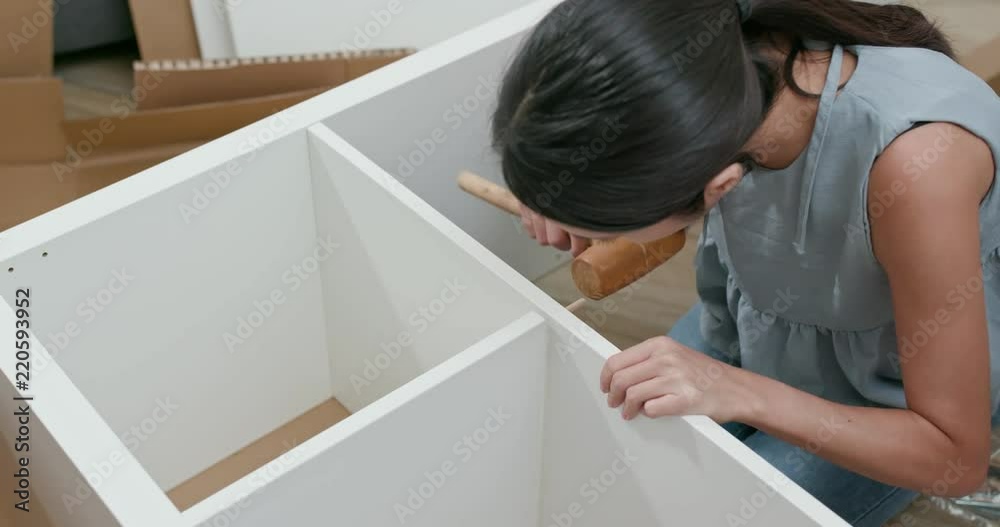 Woman assembling a shelf at home Woman assembling a shelf at home