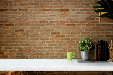 Mockup workspace vintage books, dry flower, office stationery and cork frame over red brick wall.