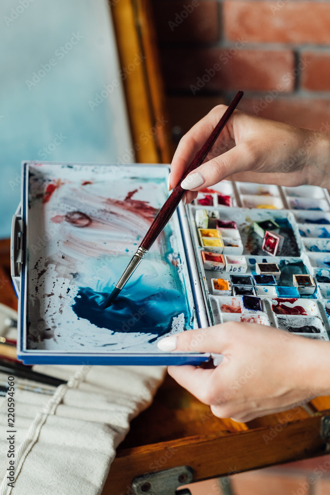 Fototapeta premium art painting hobby. creative lifestyle. artist mixing watercolors preparing to draw picture. ink dyes colorful palette. talent inspiration creation and self expression concept