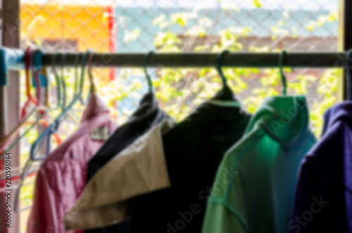 Blur clothing hang on hangers in house