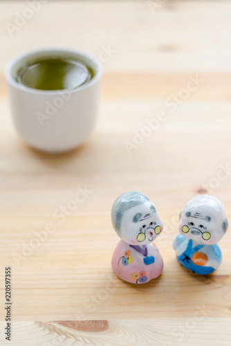Grandfather and grandmother ceramic dolls on wooden ground