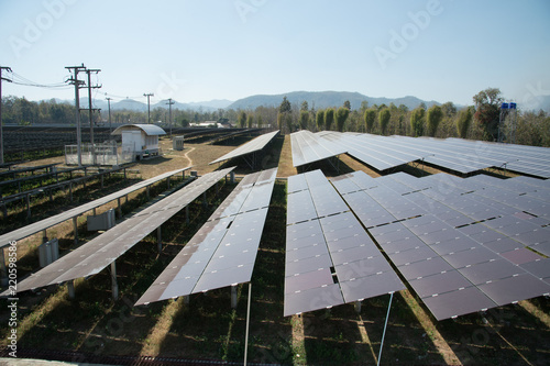 View of solar farm in sunlight with blue sky, dirty solar cell  array, green energy concept.