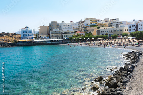 Agios Nikolaos. Crete. Vacationers on the beach at the waterfront Akti PapaNikolaou Pagkalou