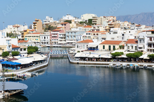 Fototapeta Naklejka Na Ścianę i Meble -  Agios Nikolaos. Crete. Buildings on the shore of Voulismeni Lake and boats at the pier