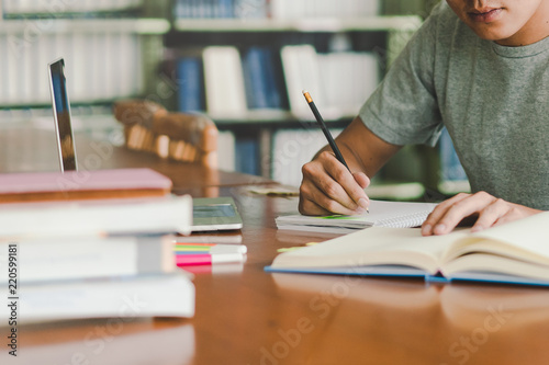 Photography male asian student studying and reading book in library
