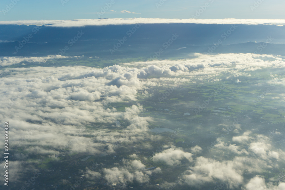 View of blue sky with cloud and city scape in plane window seen.