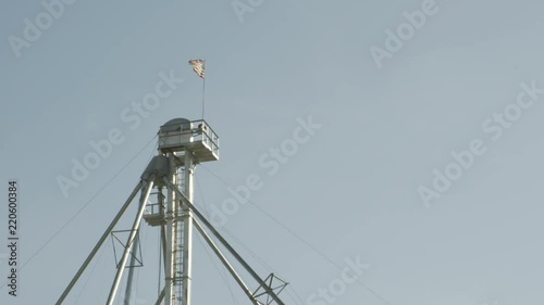 American flag waving on top of industrial metal tower