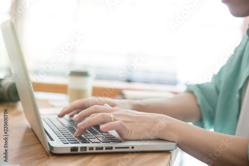 Business male hands typing on a laptop keyboard on desk with a cup of coffee in evening light,Urgent agenda,Freelance work at home office.